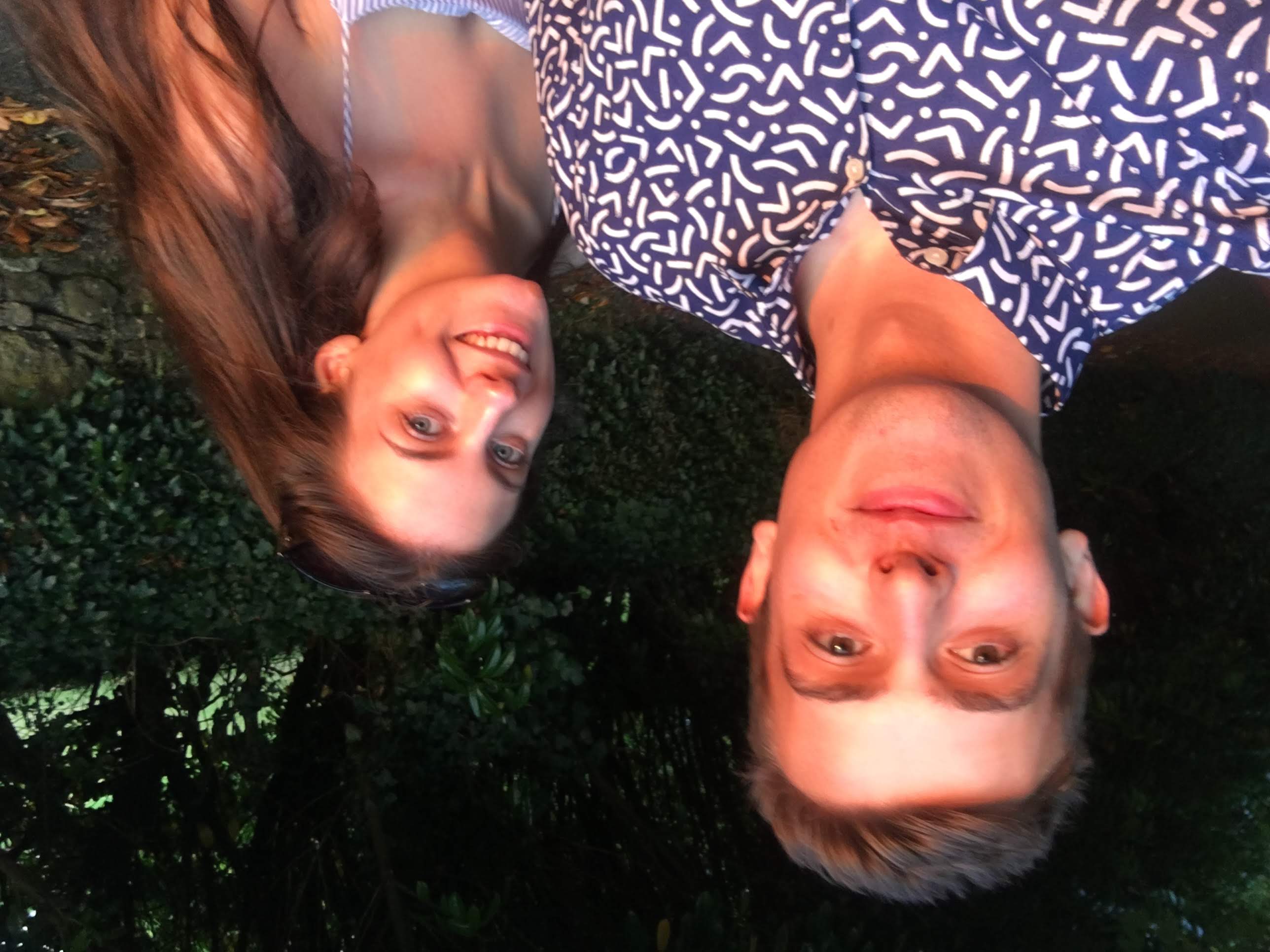 Joe and Naomi lit by the sunset, stood smiling at the camera